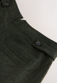 Pantaloni din material verde închis cu textură periată, prevăzuți cu închidere cu nasturi, buzunare laterale și croială ajustată.