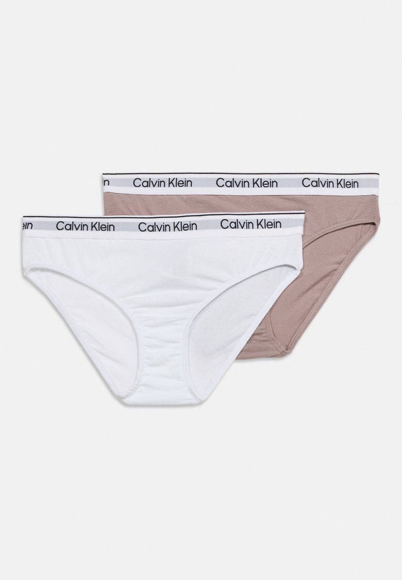 Δύο βαμβακερά εσώρουχα Calvin Klein σε λευκό και μπεζ χρώμα με ελαστικές ζώνες μέσης με λογότυπο, τοποθετημένα επίπεδα σε λευκό φόντο.
