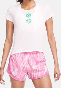 Light pink short-sleeve t-shirt with "JUST DO IT" print in green, paired with pink shorts featuring white abstract stripes and shapes.