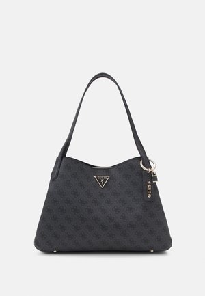 Black Guess shoulder bag with patterned logo print, triangular metal logo plaque, and attached branded keychain on a single strap.