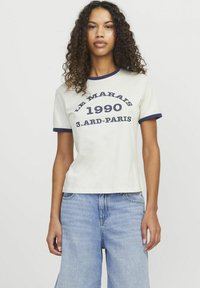 Witte katoenen t-shirt met marineblauwe rand, voorzien van gedrukt tekst: "LE MARAIS 1990 3.ARD-PARIS." Casual pasvorm met korte mouwen.