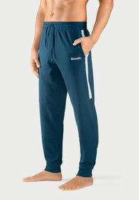 Helleblau Jogginghose aus einem weichen Stoff mit weißen Seitenstreifen und elastischem Bund. Verfügt über eine Vordertasche und das "Bench."-Logo in Weiß.