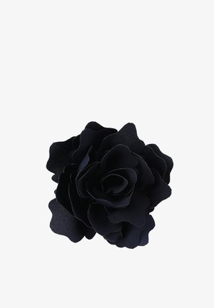 Broche de rosa de tela negra con múltiples pétalos en capas, textura suave y un ligero brillo, creando una apariencia de flor realista.