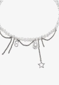 Collana di perle con dettagli in catena argentata. Presenta gocce di perla irregolari e un ciondolo a forma di stella. Sezioni di catena in metallo twisted.