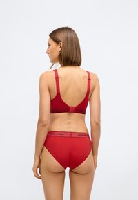 Κόκκινο στηθόδεσμο Calvin Klein και αντίστοιχα ψηλοκάβαλα εσώρουχα, κατασκευασμένα από μαλακό ύφασμα, με ρυθμιζόμενους ιμάντες και ελαστική ζώνη με λογότυπο.
