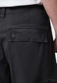 Sorte denim-shorts med en baglomme, dobbelt syning og en struktureret overflade. Designet til holdbarhed og funktionalitet.