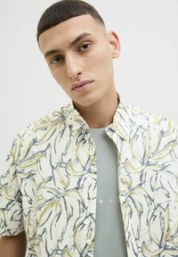 Kortærmet skjorte i let stof med et blomster abstrakt mønster i gul og blå, med knap- ned krave og afslappet pasform.