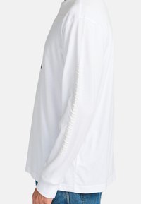 Long-sleeve white t-shirt made of cotton, featuring a black graphic on the front and text "OF THE OPPOSITES" printed vertically on the sleeve.
