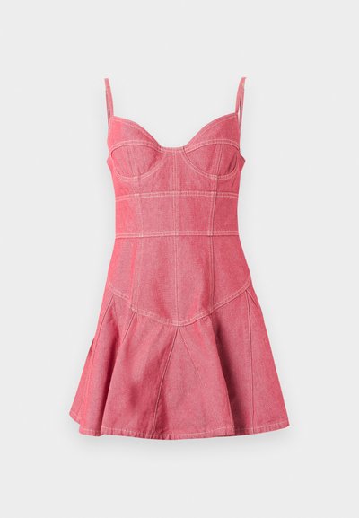 Mini-robe sans manches en denim rose avec bustier ajusté, bretelles réglables et jupe évasée avec détails de surpiqûres blanches visibles.