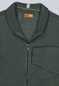 Dunkelgrüner Pullover mit Reißverschluss, strukturierter Strickware, geripptem Kragen und einer Brusttasche. Verfügt über ein orangefarbenes Markenlabel und einen Reißverschlussanhänger.