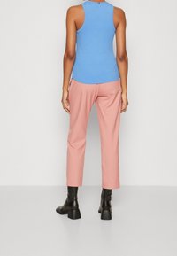 Blå ribbad tanktopp, ljusrosa cropped byxor och svarta klackade ankelboots. Enkelt mönster, åtsittande topp, lös passform på byxorna.