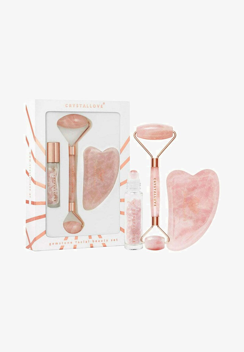 Set de rouleaux en quartz rose dans une boîte blanche avec des accents en or rose ; comprend un petit rouleau, un grand rouleau et un outil gua sha en forme de cœur.