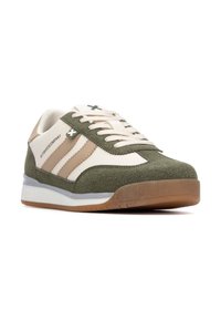 Zapatillas verdes y beige con materiales de ante y textil, que presentan un diseño a rayas, cordones blancos y una suela de goma. Detalle destacado del logo.
