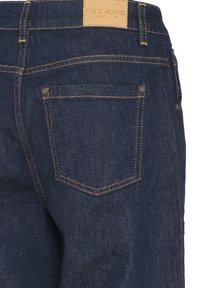 Donkerblauwe denim jeans met een textuurafwerking, voorzien van oranje stiksels, twee achterzakken en een tan leren merklabel op de tailleband.