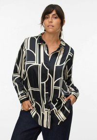 Black and cream button-up shirt featuring a geometric pattern, long sleeves, and a smooth, shiny fabric with a relaxed fit.