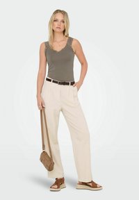 Oliven tank top med blondedetaljer, cremefarvede højtaljede bukser, brun bælte og matchende crossover taske. Brune espadrille sandaler fuldender looket.