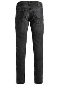 Schlanke schwarze Denim-Jeans im Slim-Fit-Stil verfügen über ein klassisches Fünf-Taschen-Design mit einer glatten Textur und subtilen Nähten an den hinteren Taschen.