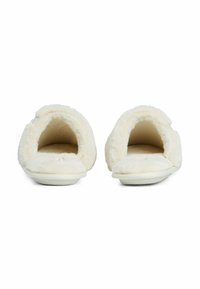 Een paar witte pluche binnenslippers met ronde openingen en zachte demping, van voren getoond op een witte achtergrond.