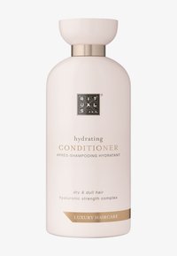 Hydrerande balsamflaska i mjuk rosa, rund form med ett guldaccent vid halsen. Etiketten visar detaljer i guld och svart.