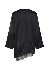 Blouse noire en satin à manches longues, ourlet asymétrique et bordure en dentelle noire en bas, vue de dos sur fond blanc.