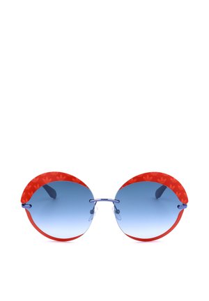 Occhiali da sole rotondi con lenti sfumate blu e montatura rossa curva con un motivo sottile di piccoli loghi.