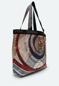 Borsa in tela con motivi a spirale multicolori, caratterizzata da una banda superiore nera con la scritta "GATTI NONI" e manici piatti e resistenti.