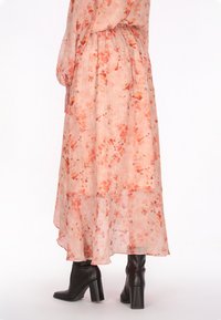 Langes, fließendes Kleid aus transparentem, leichtem Stoff mit pinkem Grund und floralen Mustern in Orange- und Pfirsichtönen. Verfügt über eine taillierte Taille und einen mehrlagigen Saum.