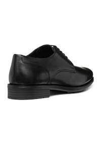 Scarpe eleganti in pelle nera con superficie liscia, punta rotonda e tacco basso. Presentano un design con lacci e delicati dettagli di cucitura.