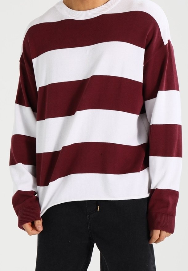 Pull à manches longues rayé bordeaux et blanc avec un large col et des poignets côtelés, présentant une coupe ample et une texture en maille douce.
