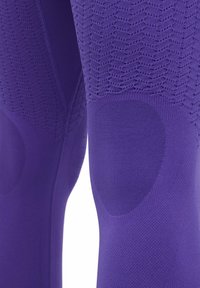 Leggings atletici viola con un motivo testurizzato e imbottitura per le ginocchia senza cuciture per protezione, realizzati in un tessuto elastico e traspirante.