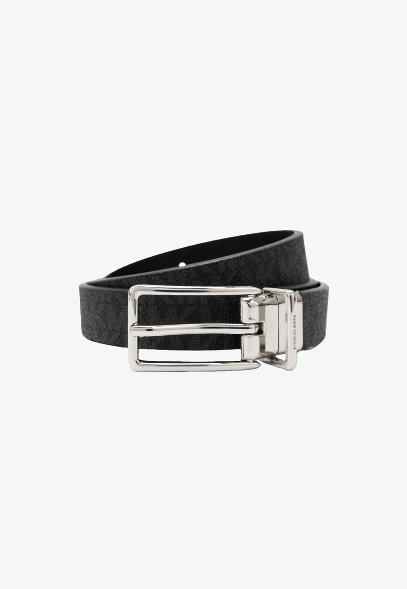 Ceinture en cuir noir texturé avec boucle rectangulaire argentée brillante, enroulée sur un fond blanc.