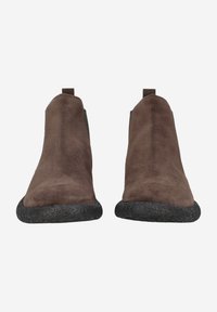 Bottines en daim marron avec une semelle en caoutchouc noir texturé, dotées d'une languette à l'arrière et d'un design épuré sans fermetures visibles.