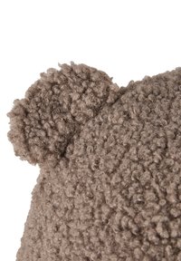 Close-up of a textured brown knitted fabric with a rounded bear ear detail on a white background.