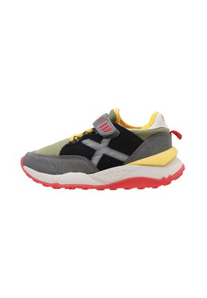 Zapatilla multicolor con malla verde, superposición de ante negro, acentos amarillos, suela roja y correa ajustable para un ajuste seguro.