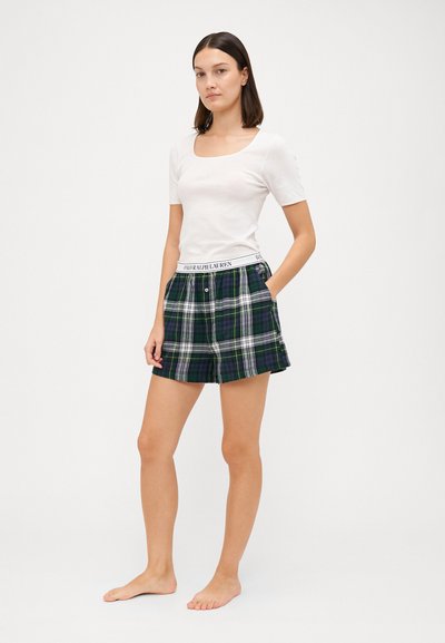Bílá přiléhavá tričko s čtvercovým výstřihem spárované s kostkovanými šortkami v zelené, modré a bílé barvě, s elastickým pasem a značkováním.