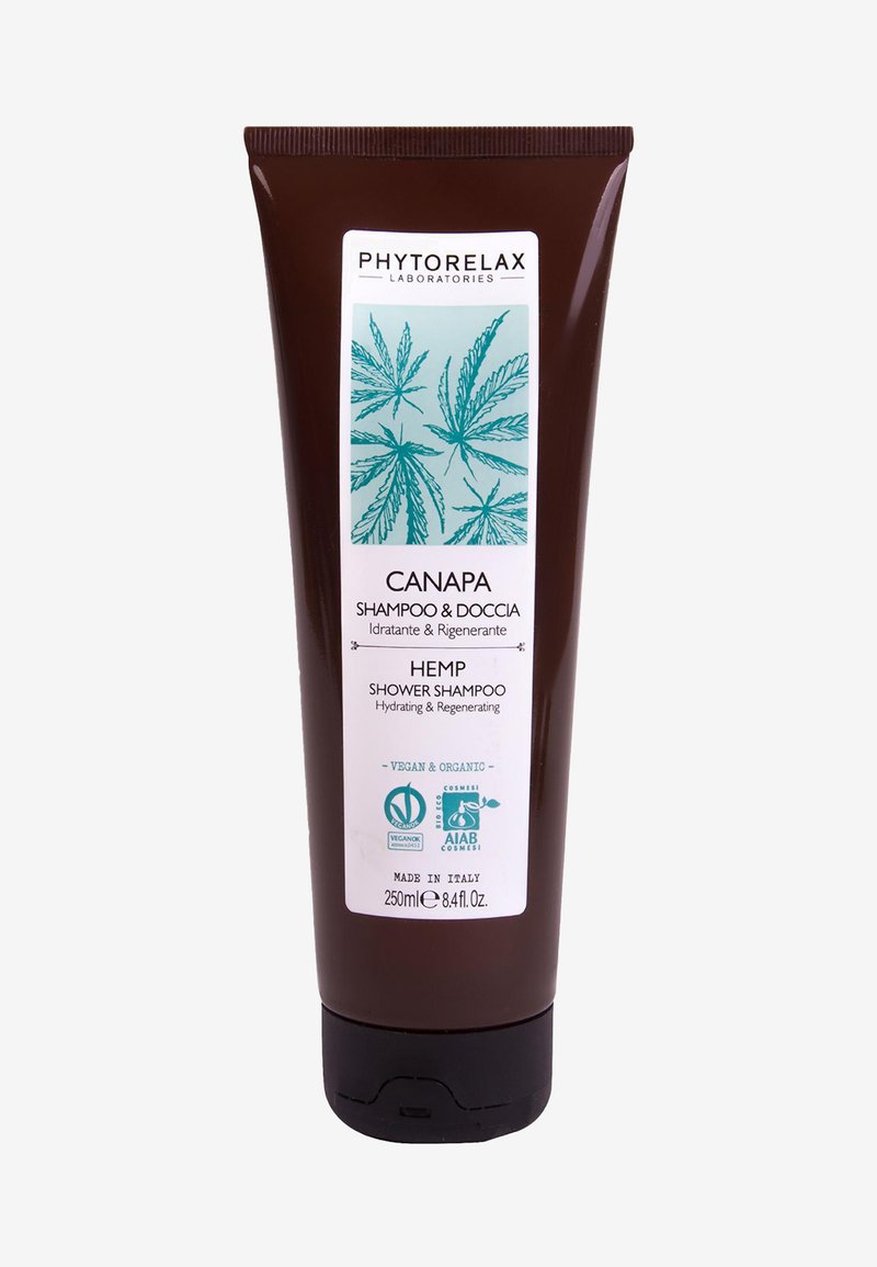 Szampon do włosów w kostce w brązowej tubie, ozdobiony ilustracjami zielonych liści konopi, z białą etykietą oraz certyfikatami dla składników wegańskich i organicznych.