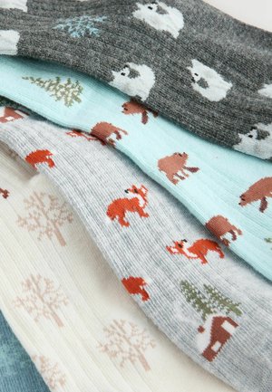 Colorful patterned socks featuring polar bears, trees, foxes, and cabins, made of soft fabric in various shades of gray, blue, and cream.