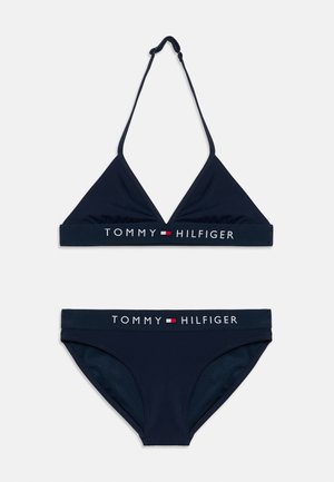 Ensemble bikini deux pièces bleu marine comprenant un haut triangle avec bretelles réglables et un bas avec une taille contrastée portant un logo. Texture lisse.