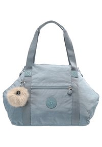 Sac à main en tissu bleu clair avec deux poignées, poche avant zippée, écusson logo circulaire et ornement pompon pelucheux détachable.