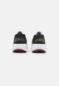 Czarne zamszowe i siateczkowe buty sportowe z białą teksturowaną podeszwą i bordowymi akcentami, z logo na pięcie i eleganckim designem.