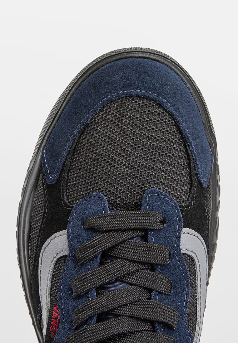 Zapatillas negras y marino con parte superior de malla texturizada, acentos de ante, cordones gruesos negros y un detalle en gris del logo en el costado.