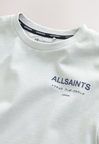 Hellgraues Crewneck-Shirt mit "ALLSAINTS" und japanischen Zeichen in Dunkelblau, die auf der Brust über "LONDON" gedruckt sind.