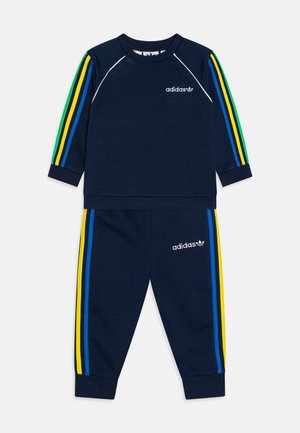 Navy tracksuit featuring long sleeves, ribbed cuffs, and elastic waistband. Three colorful stripes in blue, green, and yellow on sleeves and pants.