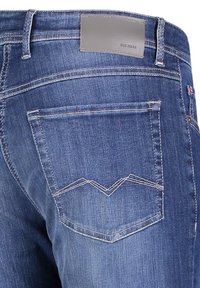Dark blue denim jeans with a textured finish, featuring a right back pocket with a zigzag stitch design and a gray fabric label at the waistband.