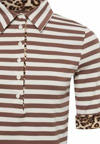 Bruine en witte gestreepte poloshirt met knoopsluiting en luipaardprintaccenten op de binnenkraag en mouwmanchetten.