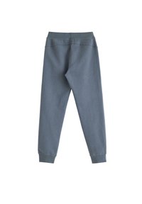 Grijze katoenen joggers met een slim fit, elastische tailleband en geribde boorden. Gladde textuur met minimale stiksel details aan de achterkant.