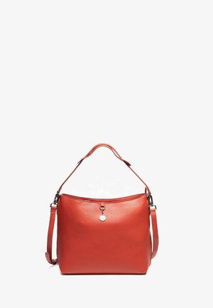 Rote Lederhandtasche mit strukturiertem Oberflächen, verstellbarem Schultergurt und einem dekorativen Metallanhänger auf der Vorderseite. Weiche, abgerundete Form.
