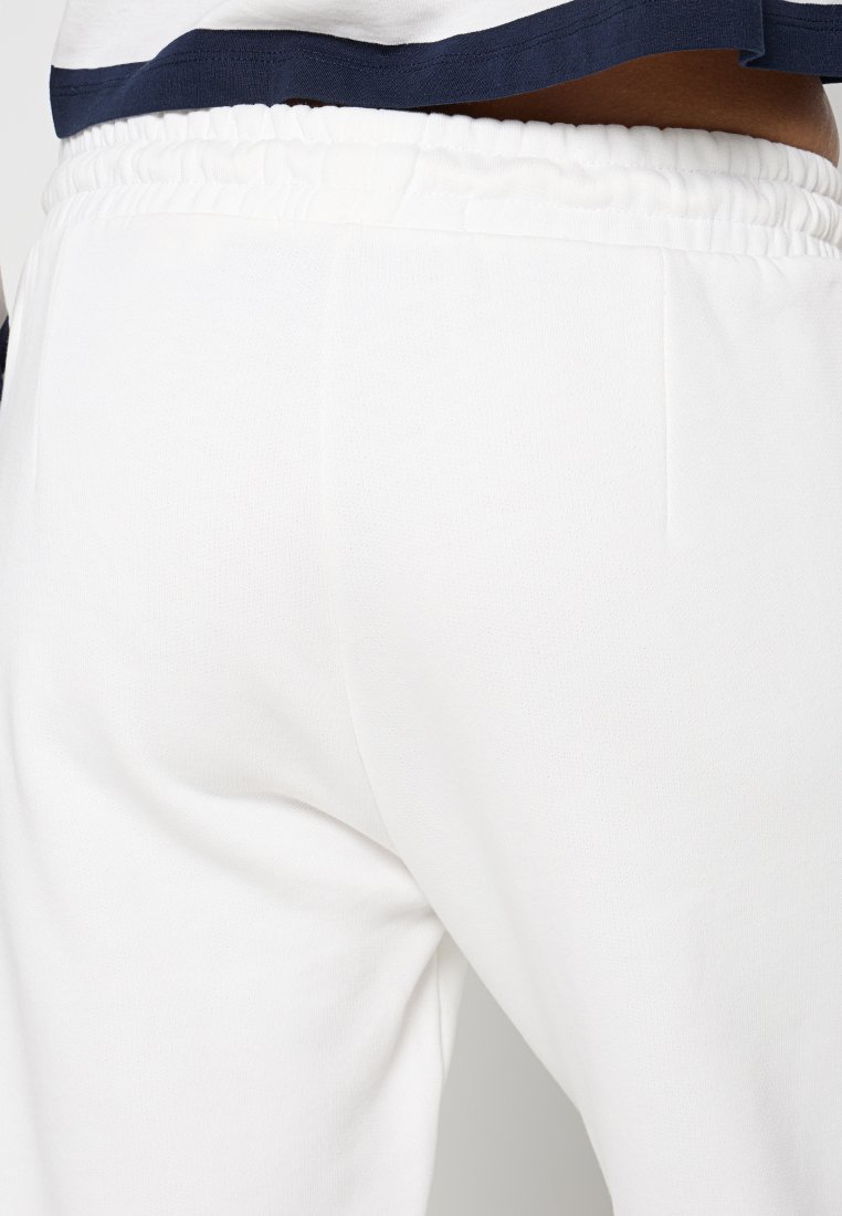 Weiße Sweatpants aus strukturiertem Material mit einem Elastikbund und schlichtem Design. Keine sichtbaren Taschen oder zusätzlichen Details.