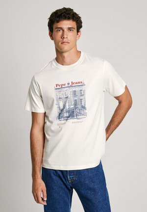 Bijela pamučna majica s plavim grafičkim otiskom koji prikazuje zgradu, s natpisom "Pepe Jeans!" i ležernim krojem. Uparena s plavim trapericama.