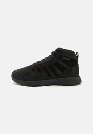 Baskets montantes noires avec lacets à l’avant, col rembourré, semelle texturée et marquage discret sur le côté et la zone du talon.